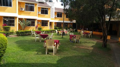 a group of tables and chairs in front of a building at Hotel Oasis in Morogoro