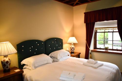 a bedroom with a large bed with two towels on it at Cloncaird Castle Estate Cottages in Maybole