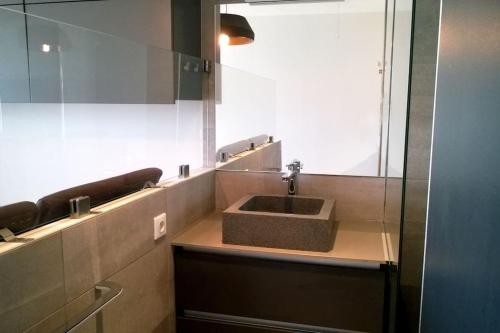 une salle de bain avec un lavabo et un miroir dans l'établissement Studio 216, Héliopolis AB au village naturiste, au Cap d'Agde
