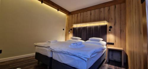 1 dormitorio con 1 cama con sábanas y almohadas blancas en Na Górce en Przemyśl