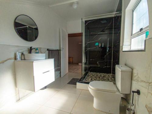 a bathroom with a shower and a toilet and a sink at House Musantwi in Kroonstad