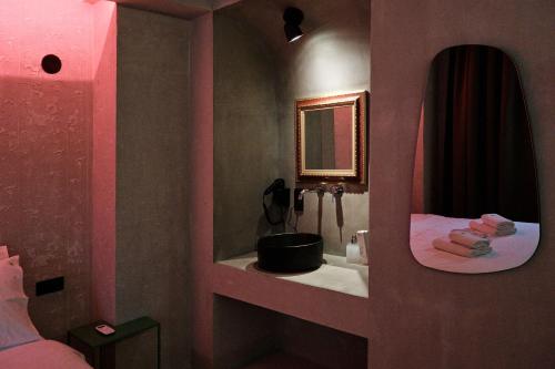 a pink bathroom with a sink and a mirror at Paradox in Thessaloniki
