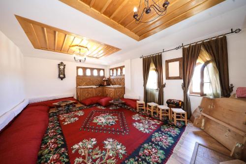 a bedroom with a large bed with a red rug at Hotel Çarshia e Jupave in Gjakove