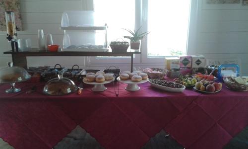 a table with a red table cloth with food on it at Villa Ghetta Country House in Leverano
