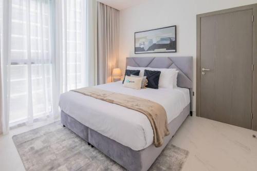 a bedroom with a large bed and a large window at HiGuests - Step Into Heaven In This Lakeside Apartment in Dubai