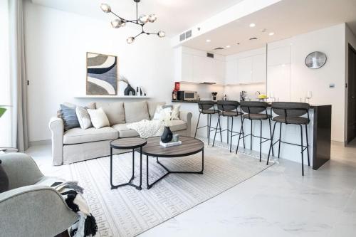 a living room with a couch and a kitchen at HiGuests - Step Into Heaven In This Lakeside Apartment in Dubai