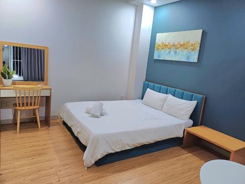 niewielka sypialnia z łóżkiem i biurkiem w obiekcie SUNNY HOME w Ho Chi Minh