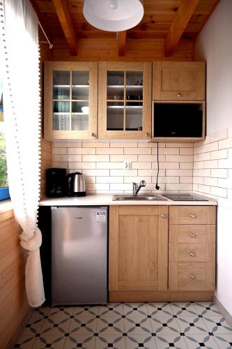 a kitchen with a sink and a dishwasher at Osada Rybacka in Podamirowo