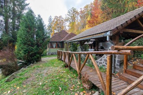 a wooden bridge in front of a house at Esigman - log cabin in Transylvania in Filia