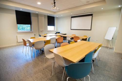 a classroom with tables and chairs and a whiteboard at Edinburgh Central Accommodation in Edinburgh