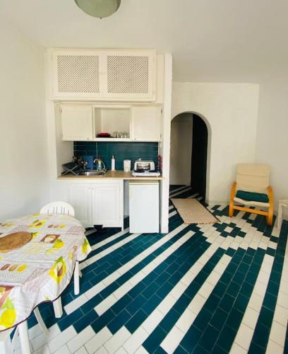 a bedroom with a bed and a kitchen with a counter at Studio bord de mer à louer in Hammam Sousse