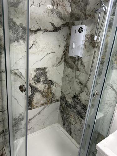 a shower with a glass door in a bathroom at London Rd Apartment's in Leicester