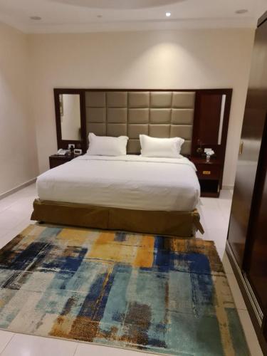 a bedroom with a large bed and a rug at شاليهات دشيل لبيوت العطلات الاقتصادية in Taif