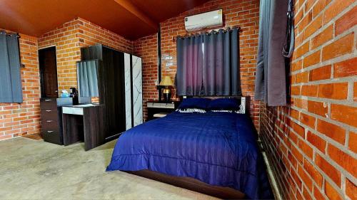 1 dormitorio con 1 cama en una pared de ladrillo en บ้านสวนลุงแจน ฟิชชิ่งพาร์ค แอนด์ รีสอร์ท, 