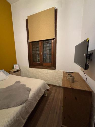 a bedroom with a bed and a desk with a television at Expreso terminal in Montevideo