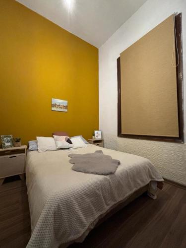 1 dormitorio con 1 cama grande y pared amarilla en Expreso terminal, en Montevideo