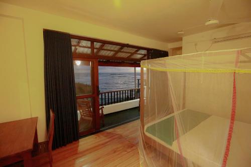 a room with a balcony with a view of the ocean at New Ocean Vibes in Weligama