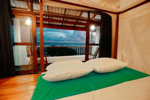a bed in a room with a view of the ocean at New Ocean Vibes in Weligama