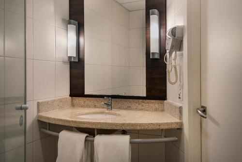 a bathroom with a sink and a mirror at Best Western Salvador Hangar Aeroporto in Salvador