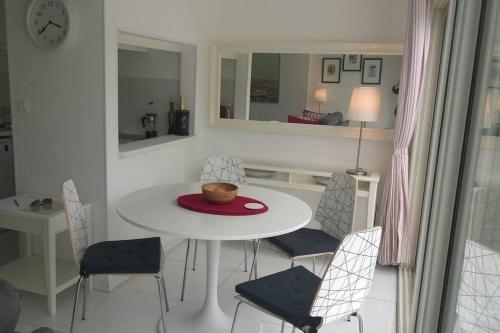 une salle à manger blanche avec une table et des chaises blanches dans l'établissement Villa 3, Port Nature au village naturiste, au Cap d'Agde