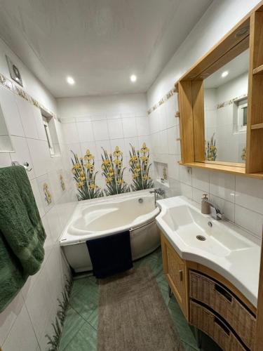 a bathroom with a tub and a sink and a bath tub at House By The Sea With Hot Tub in Rīga