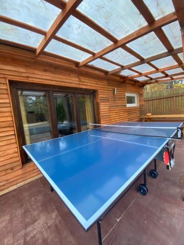 a ping pong table in front of a house at House By The Sea With Hot Tub in Rīga