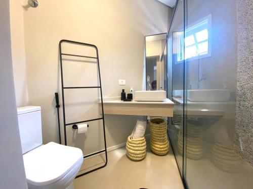 La salle de bains est pourvue de toilettes, d'un lavabo et d'un miroir. dans l'établissement Praia do Engenho - Apart Lindo e Novíssimo 30m da praia, à São Sebastião