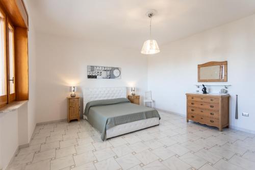 een witte slaapkamer met een bed en twee nachtkastjes bij Villetta Chiara per gruppi - Apulia Home in Ugento