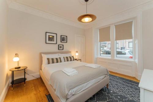 a white bedroom with a bed and a window at Beautifully Renovated 2 Bedroom Apartment in Stirling