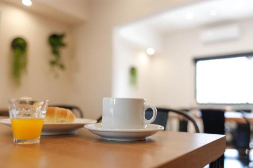 サン・ペドロにあるSan Pedro Hotel & Restóのテーブルの上にオレンジジュースのカップとパンの皿