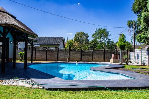 a swimming pool with a gazebo in a yard at House Musantwi in Kroonstad