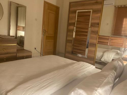sypialnia z dużym białym łóżkiem i lustrem w obiekcie Nouakchott INN w mieście Nawakszut