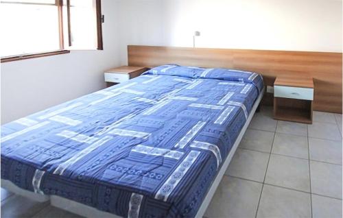 1 cama con edredón azul en una habitación en Lovely Apartment In Rosolina Mare With Kitchen, en Rosolina Mare