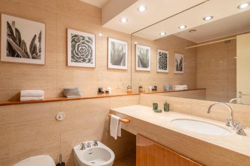 a bathroom with a sink and a toilet and a mirror at Heart Milan Apartments San Sepolcro Duomo in Milan