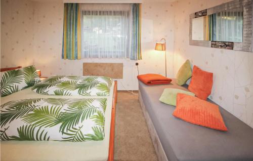 タンハイムにあるAmazing Home In Tannheim With 2 Bedrooms And Wifiのベッド2台、ソファ、ランプが備わる客室です。