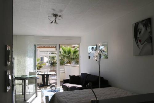 une chambre avec un lit et un salon dans l'établissement Studio 518, port Soleil au village naturiste, au Cap d'Agde