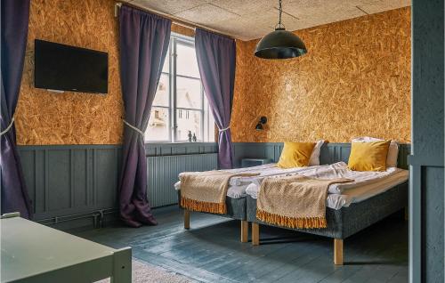 een slaapkamer met een bed en een tv aan de muur bij Cozy Apartment In Stjrnhov With Kitchen in Stjärnhov