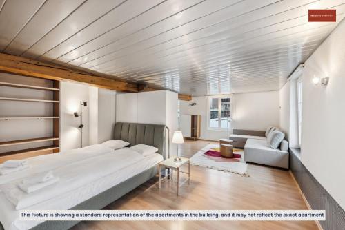 ein Schlafzimmer mit einem großen Bett und einem Sofa in der Unterkunft Affordable Living on Zurich's Edge in Dietikon