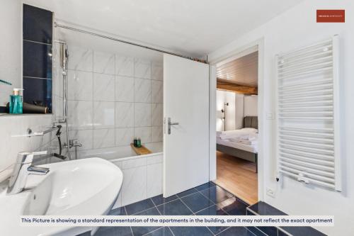 a bathroom with a tub and a toilet and a sink at Affordable Living on Zurich's Edge in Dietikon