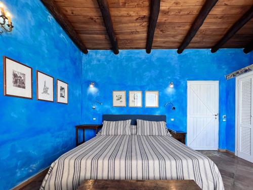 een blauwe slaapkamer met een bed en een blauwe muur bij Aeneas' Landing Resort in Gaeta