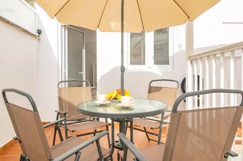 a table with chairs and an umbrella in a room at Centric in Palma de Mallorca