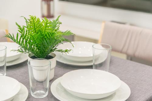 a table with plates and glasses and a potted plant at Centric in Palma de Mallorca
