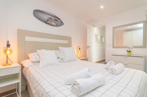 um quarto branco com uma cama grande e almofadas brancas em Centric em Palma de Maiorca