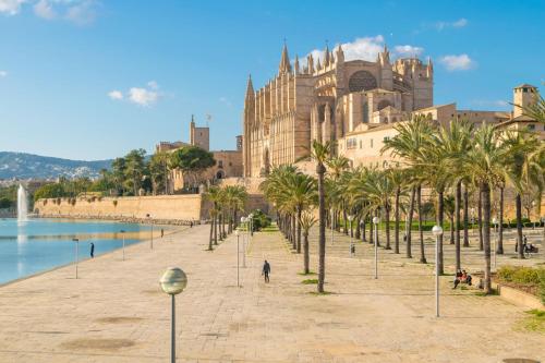 a row of palm trees in front of a building at Centric in Palma de Mallorca