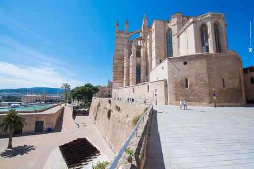 a large brick building with a clock tower next to a street at Centric in Palma de Mallorca