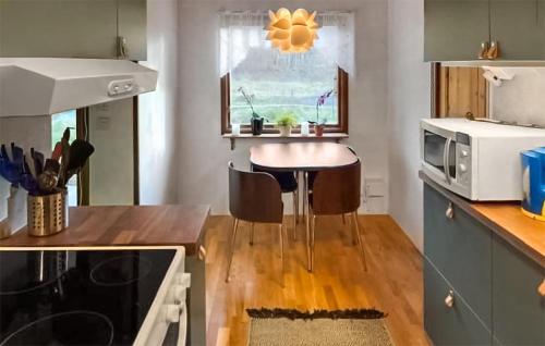 eine Küche mit einem Tisch und einer Mikrowelle in der Unterkunft 3 Bedroom Cozy Home In Backaryd in Backaryd