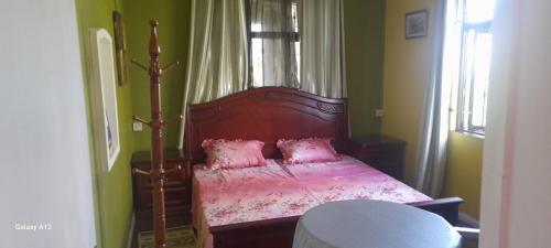 a bedroom with a bed with pink sheets and pink pillows at The Villa in Grand Baie