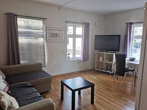 una sala de estar con un sofá y una mesa en Nice 1-bedroom apartment in Heart of the City, en Stavanger