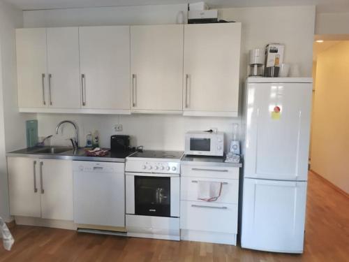 a kitchen with white appliances and white cabinets at Nice 1-bedroom apartment in Heart of the City in Stavanger