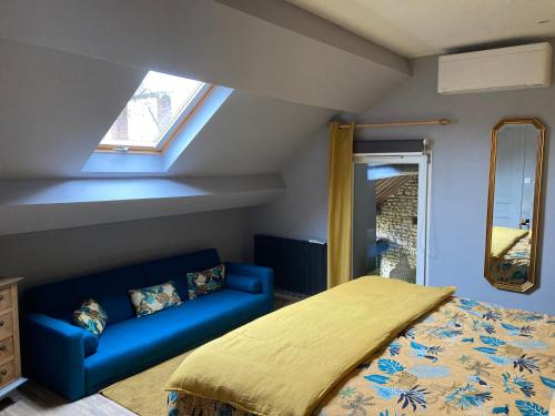 1 dormitorio con 1 cama y 1 sofá azul en la detente de neuilly en Neuilly